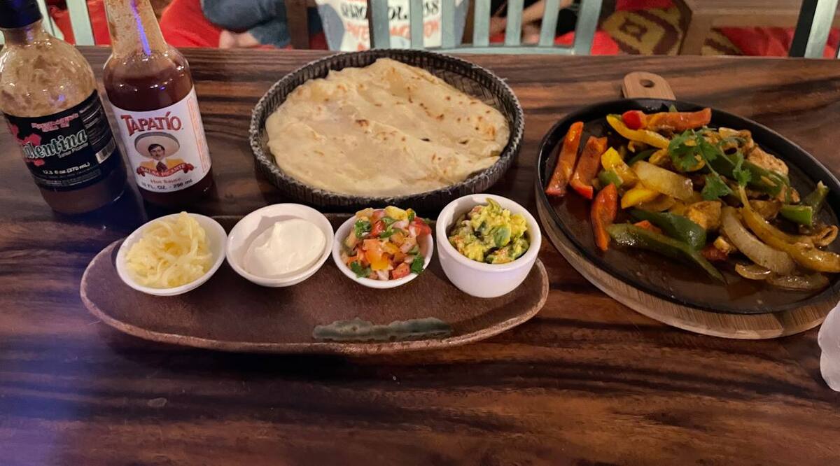 Sizzling fajitas at Pomme Battambang with tortillas, guacamole, salsa, sour cream and cheese