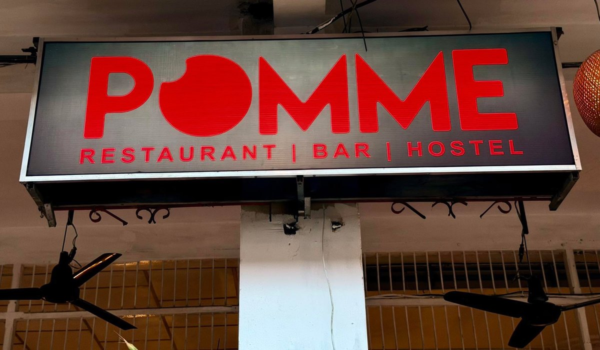 The Pomme Restaurant, Bar and Hostel sign lit up